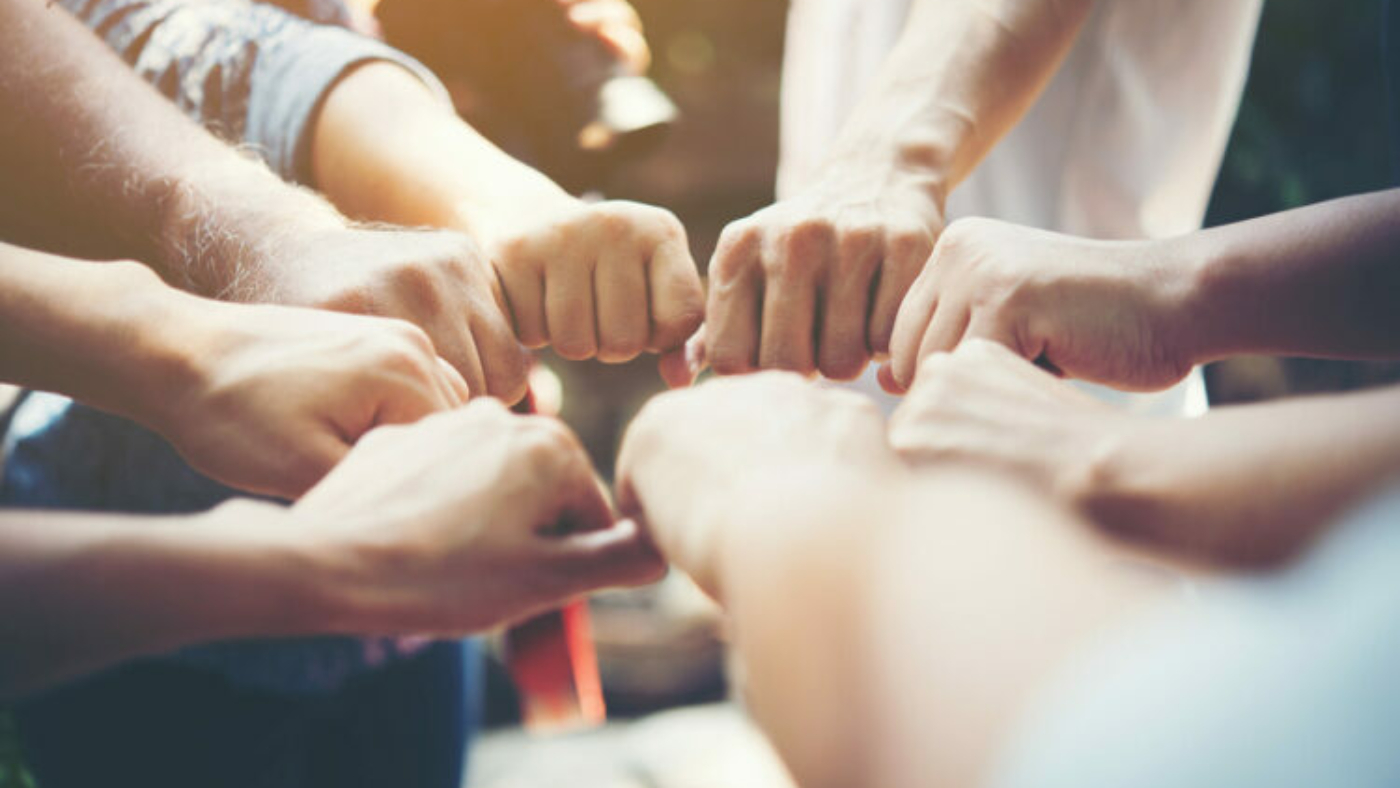 Close up of young people putting their hands together. Team with stack of hands showing unity and teamwork.
